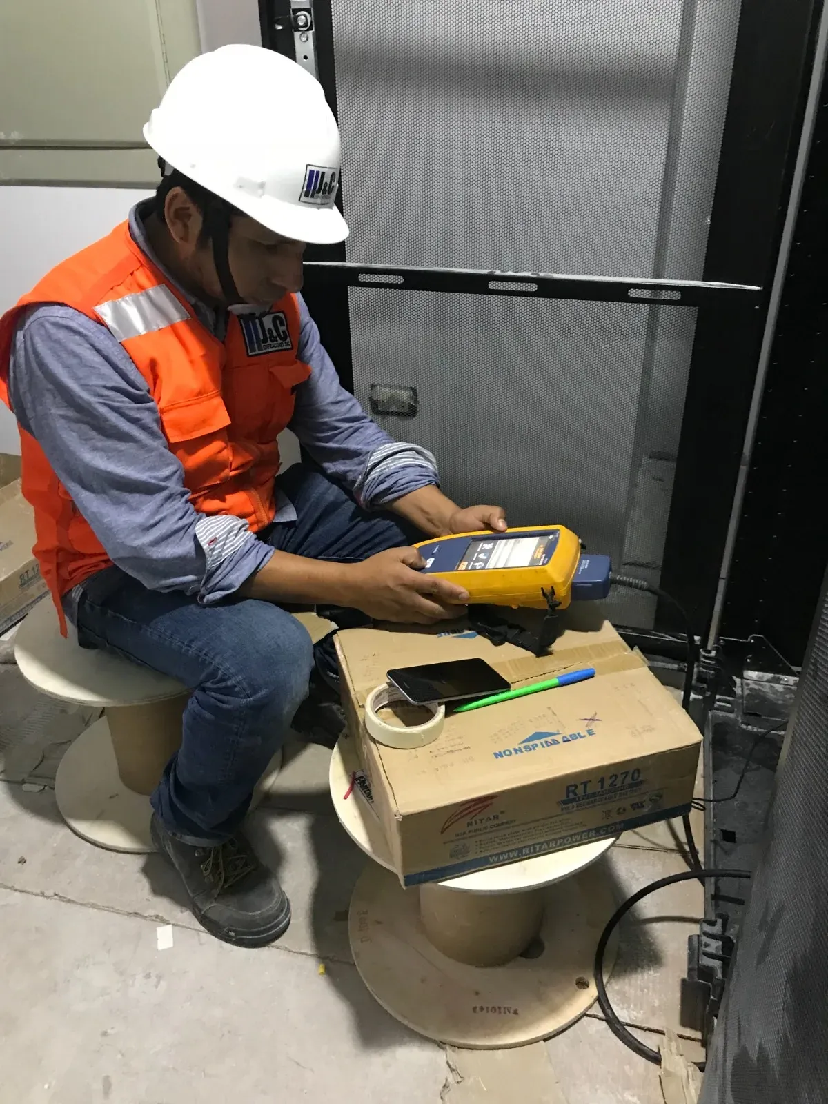 Técnico de J&C Edificaciones certificando una red de datos con equipo de medición