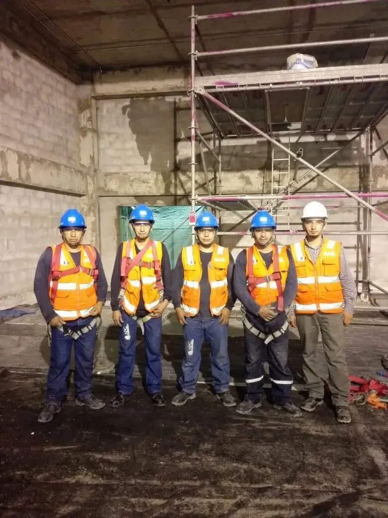 Cuadrilla de J&C Edificaciones con equipo de protección en una obra